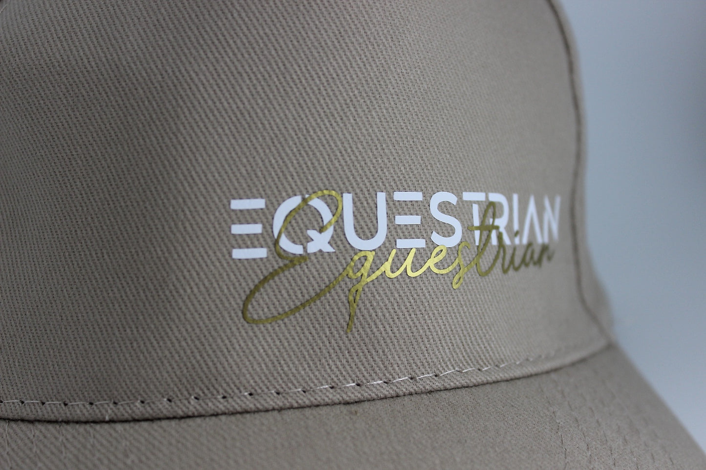 baumwoll cap in beige mit weiß und goldenem schriftzug "equestrian" reiter cap für pferdefreunde.