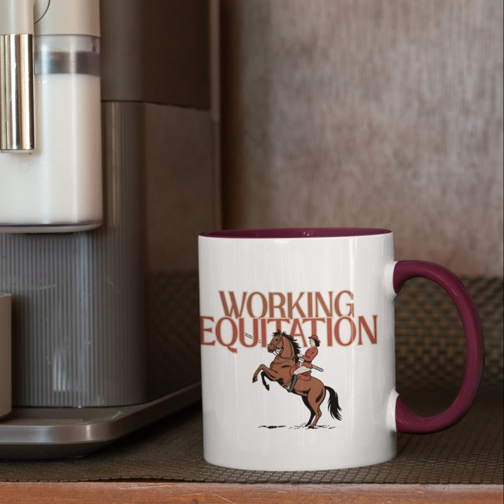 Motivtasse "Working Equitation" für Liebhaber dieser Disziplin. Motiv mit Schriftzug und im Vordergrund eine Frau auf ihrem mit Pferd und Garoccha. Weiße Tasse mit Burgundy Farbenem Henkel.