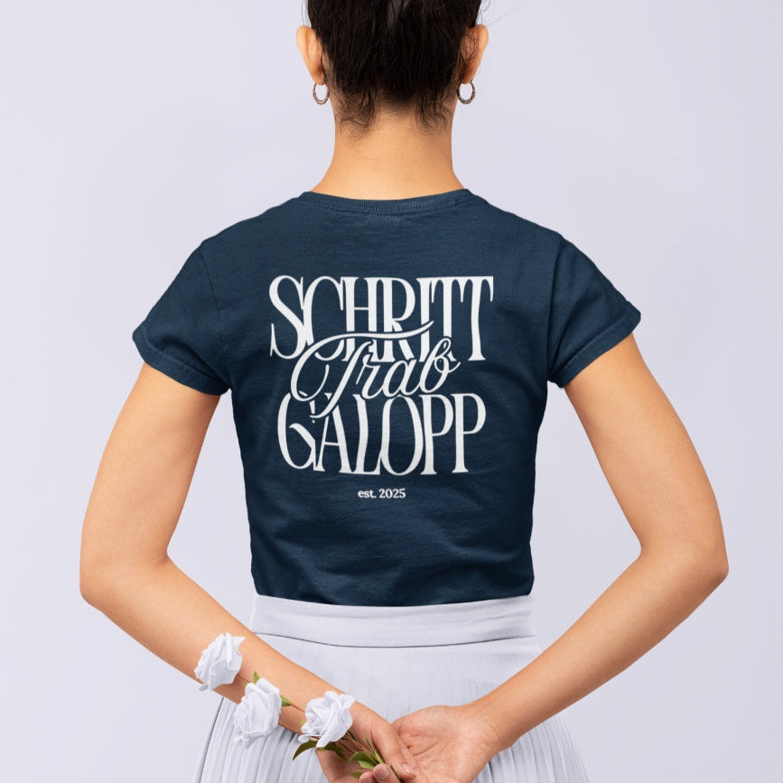 Junge Frau trägt Navy farbendes T-Shirt, figurbetont mit Rückenprint: "Schritt, Trab, Galopp"