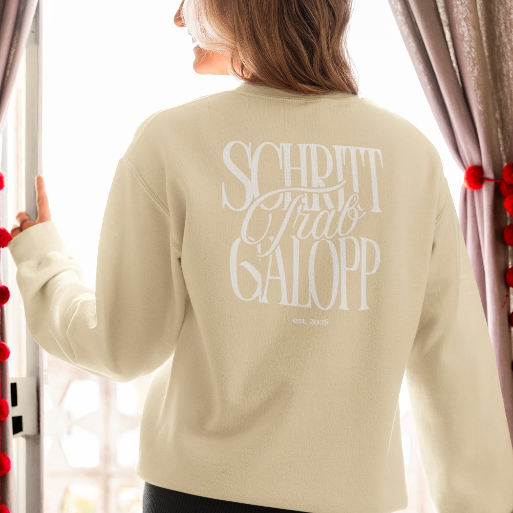 Frau Steht am Fenster und trägt unsere Sweatshirt mit Backprint "Schritt, Trab, Galopp" für Reiter-/innen. Modernes und zeitloses Design für Pferdemenschen.