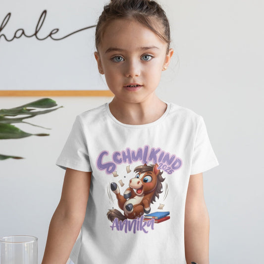 Personalisiertes Kindershirt zur Einschulung, mit Wunschnamen und süßem Pony Motiv auf Bücherstapel.