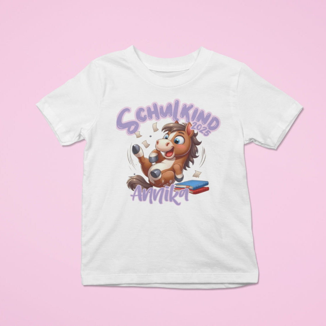 Personalisiertes Kindershirt zur Einschulung, mit Wunschnamen und süßem Pony Motiv auf Bücherstapel.