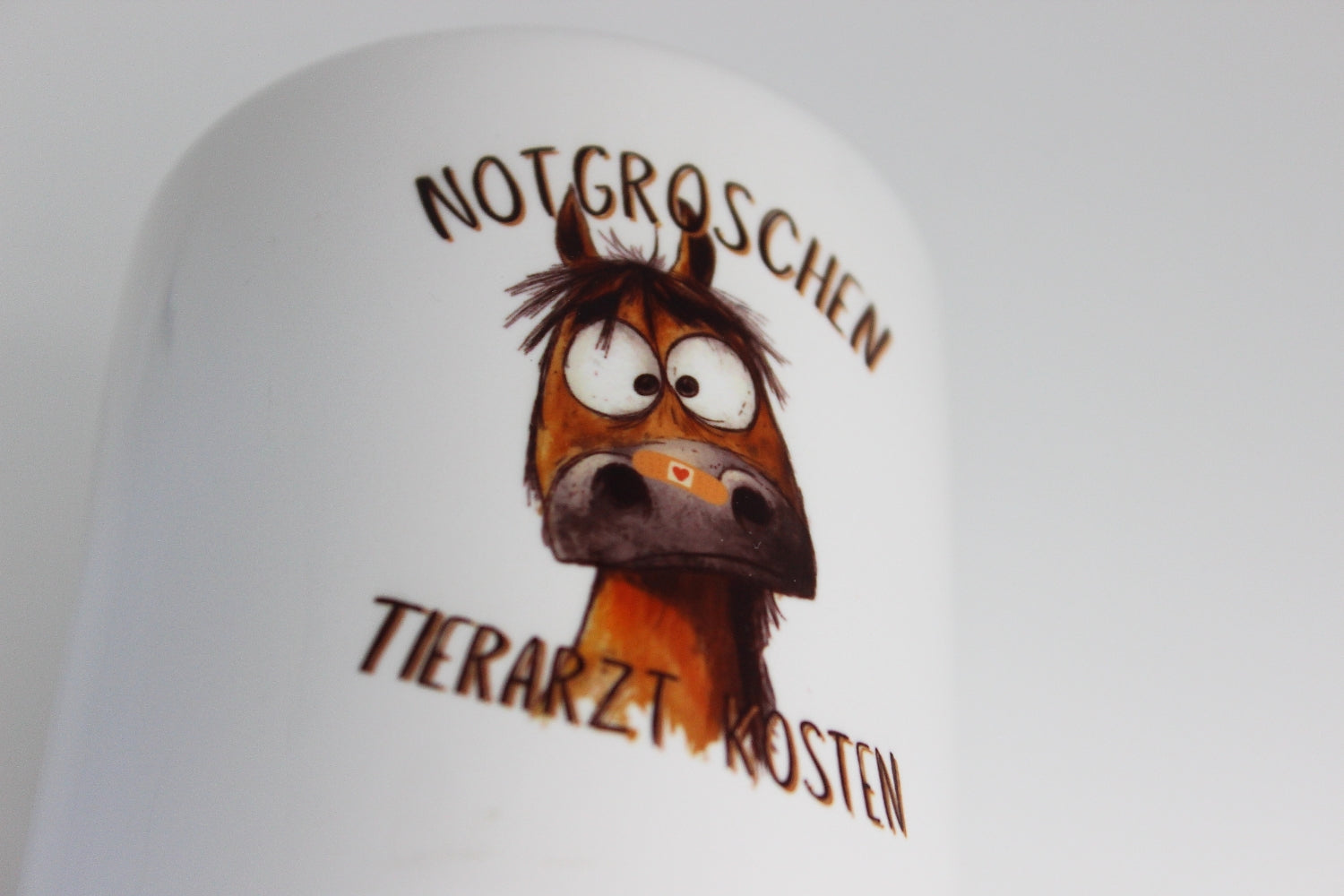 süße keramik spardose zum verschenken. print für pferdebesitzer "notgroschen tierarzt kosten" und einem pferd mit einem pflaster auf der nase

