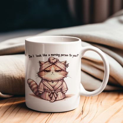 Keramiktasse mit Aufdruck "Do I look like morning person to  you?" und einer grummeligen Katze im Morgenmantel.